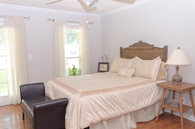 bedroom with ceiling fan, wood-type flooring, and crown molding