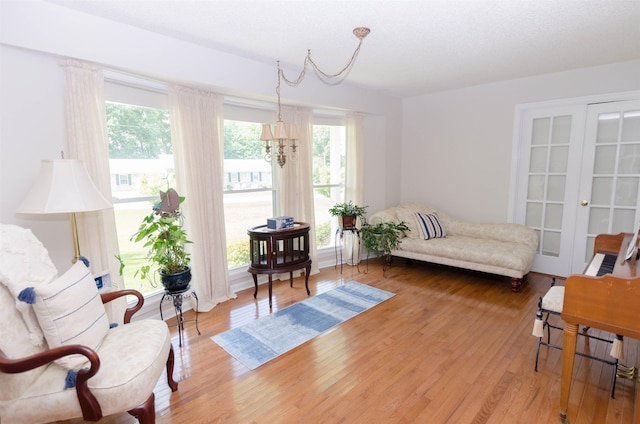 sitting room with hardwood / wood-style floors and a chandelier