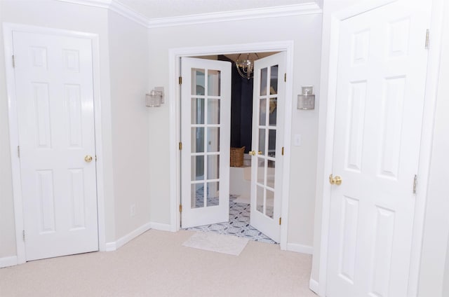 entryway with a chandelier, french doors, and ornamental molding