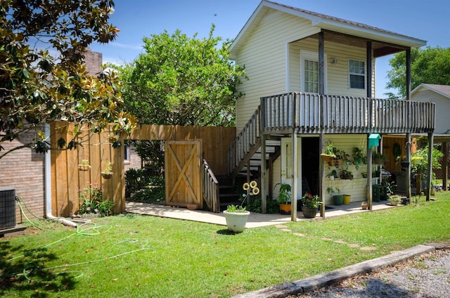 exterior space with a lawn, a deck, and central air condition unit