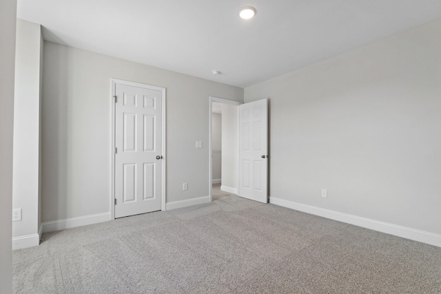 unfurnished bedroom with baseboards and light colored carpet