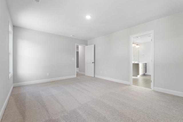 unfurnished bedroom featuring light carpet, baseboards, and recessed lighting