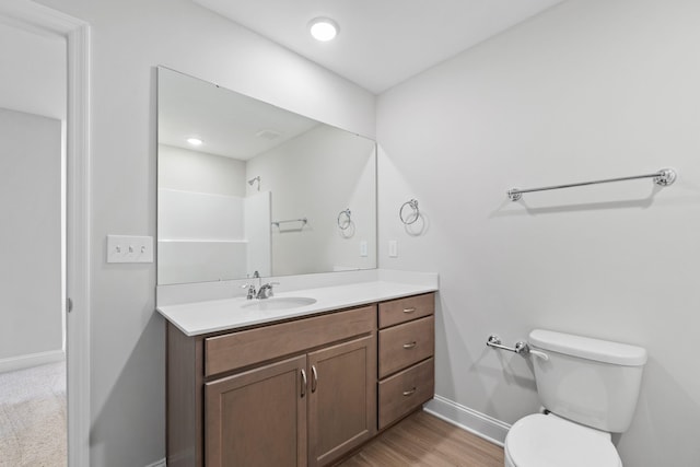 bathroom with baseboards, vanity, toilet, and wood finished floors