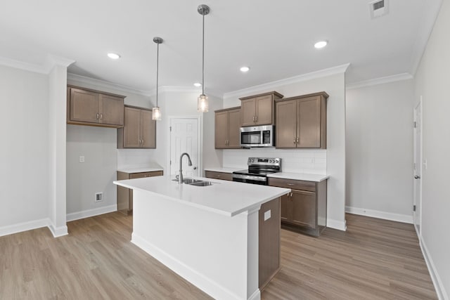 kitchen with light wood-style floors, a kitchen island with sink, appliances with stainless steel finishes, and a sink