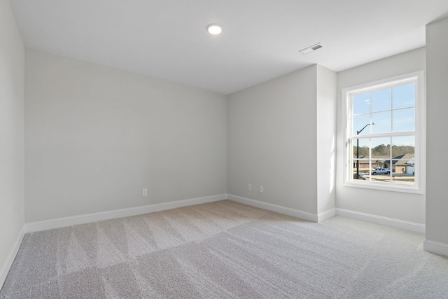 unfurnished room with light colored carpet, visible vents, baseboards, and recessed lighting