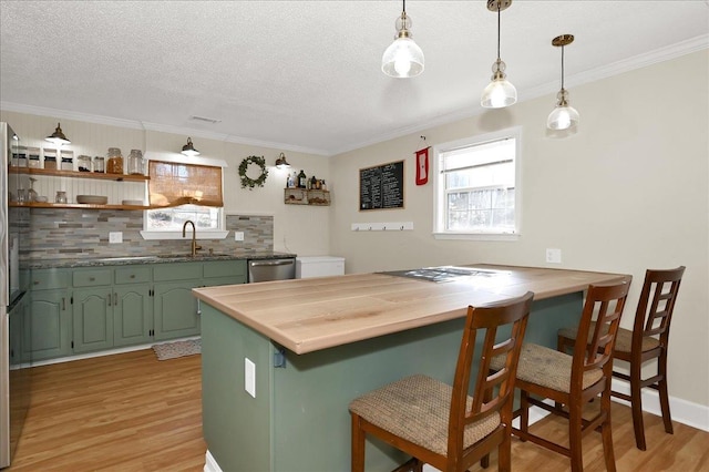 kitchen with a breakfast bar, light wood-style flooring, green cabinets, a sink, and dishwasher