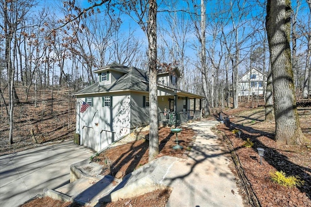 view of home's exterior featuring driveway, covered porch, and a garage