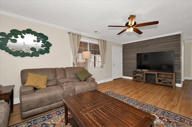 living room featuring crown molding, a textured ceiling, and wood finished floors