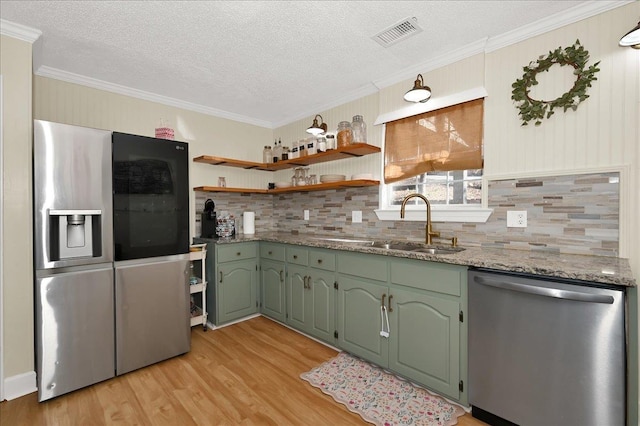 kitchen with green cabinets, stainless steel appliances, a sink, and visible vents