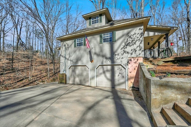 view of side of home with concrete driveway and an attached garage