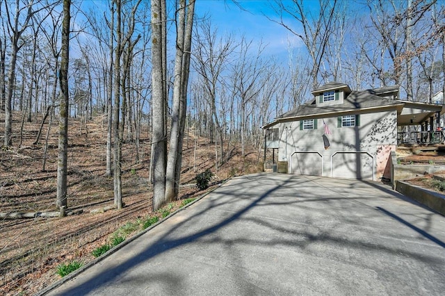 view of side of property with aphalt driveway and a garage