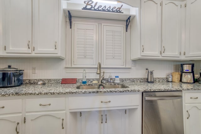  - kitchen with stainless steel dishwasher, white cabinets, and light stone counters