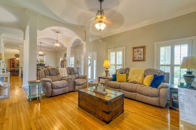  - living area with decorative columns, light wood-type flooring, a ceiling fan, arched walkways, and crown molding