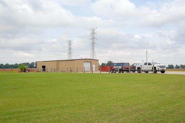  - view of home's community featuring fence, an outdoor structure, a pole building, and a lawn