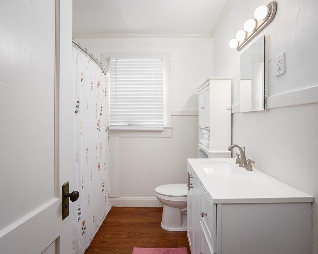 bathroom featuring curtained shower, toilet, wood finished floors, vanity, and ornamental molding