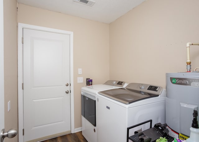 washroom with electric water heater, dark wood-type flooring, and washer and dryer