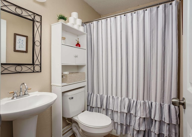 bathroom with a shower with shower curtain, toilet, and sink