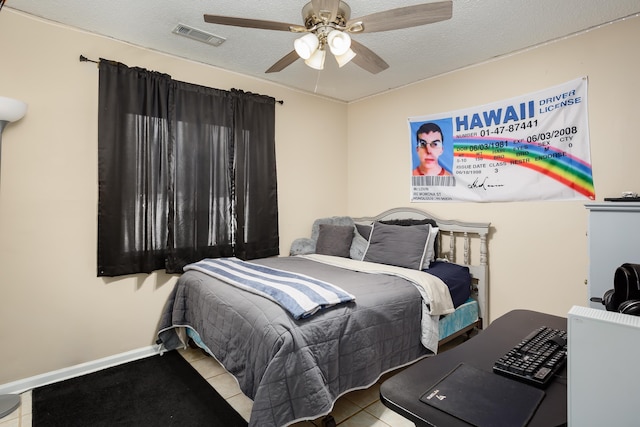 tiled bedroom with ceiling fan and a textured ceiling