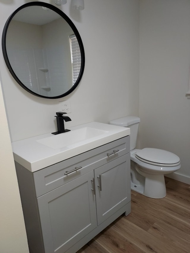 bathroom with vanity, wood-type flooring, and toilet