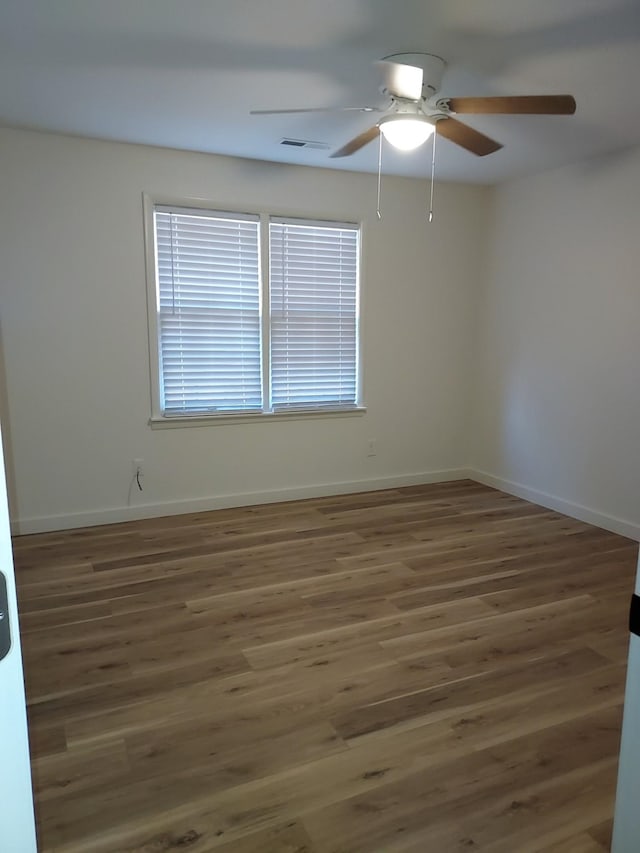 empty room featuring ceiling fan and dark wood-type flooring