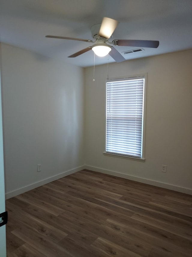 spare room with dark hardwood / wood-style flooring and ceiling fan