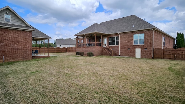 rear view of house with a gate, a patio, a lawn, a shingled roof, and fence private yard