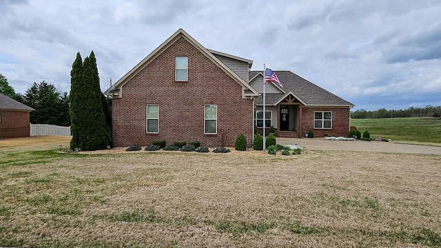 view of front facade with brick siding and a front yard