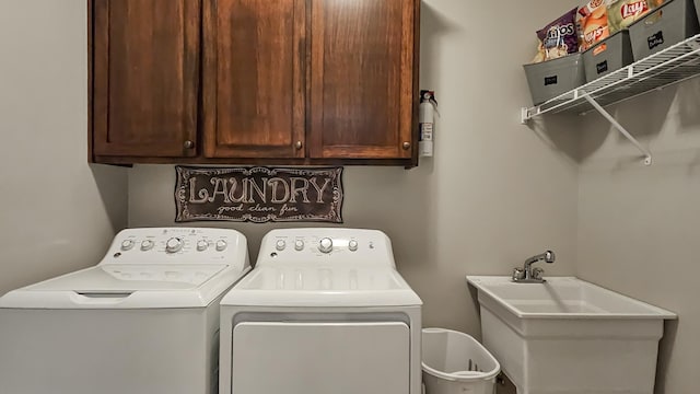 clothes washing area featuring a sink, cabinet space, and separate washer and dryer
