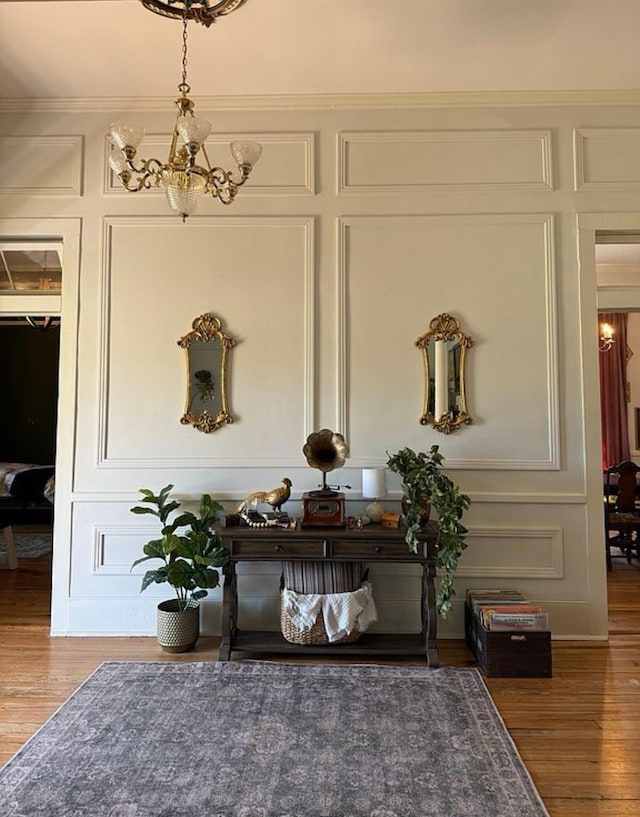  - detailed view of a decorative wall, a chandelier, and wood finished floors