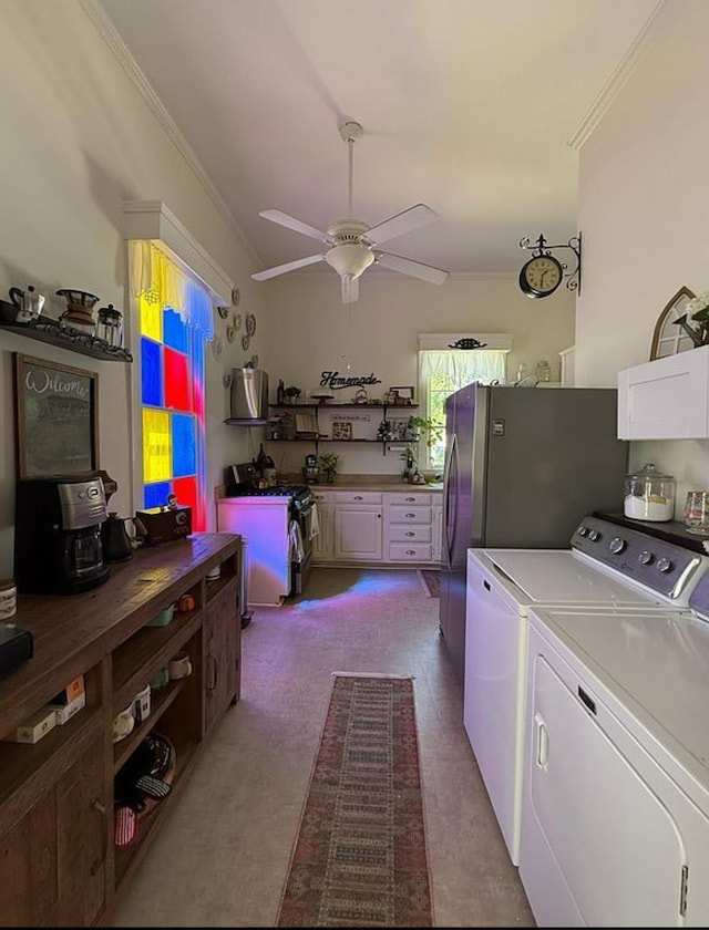  - kitchen featuring crown molding, washer and dryer, stainless steel gas stove, a ceiling fan, and white cabinets