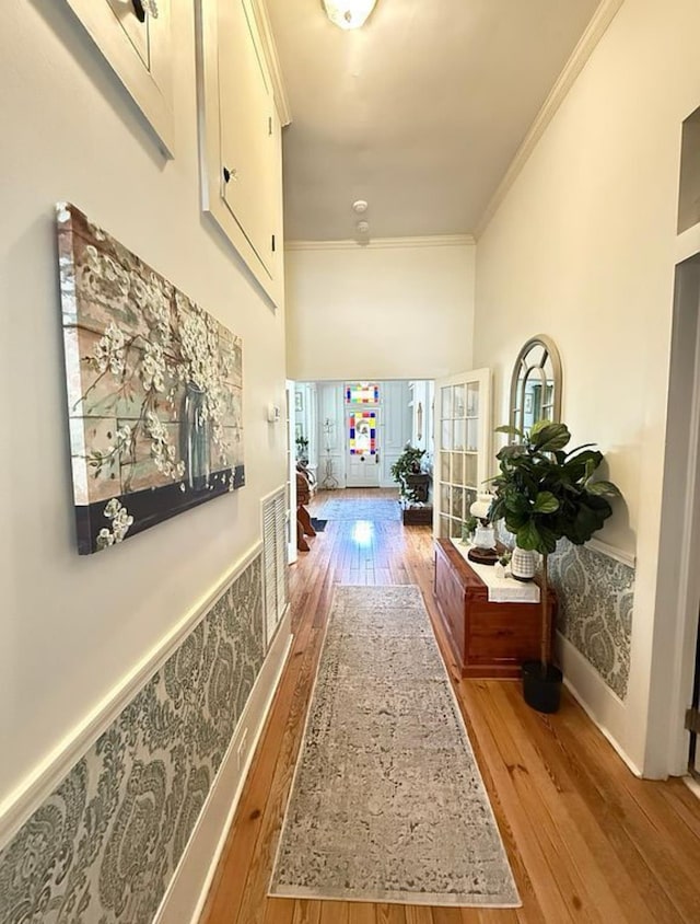  - corridor featuring hardwood / wood-style floors, crown molding, and a towering ceiling
