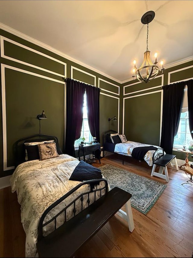  - bedroom featuring a chandelier, crown molding, multiple windows, and wood finished floors