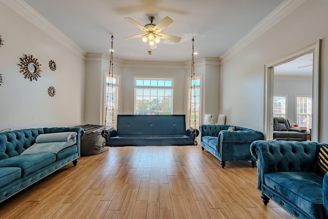 living room featuring crown molding, a healthy amount of sunlight, and light wood-type flooring