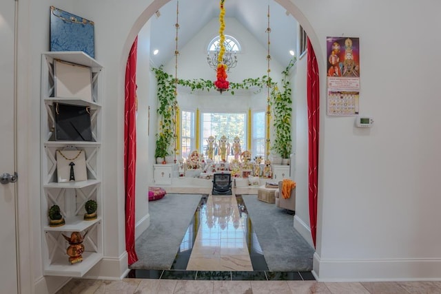 corridor featuring a healthy amount of sunlight, built in features, and vaulted ceiling