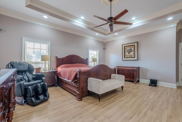 bedroom featuring ceiling fan, a raised ceiling, light wood-type flooring, and multiple windows