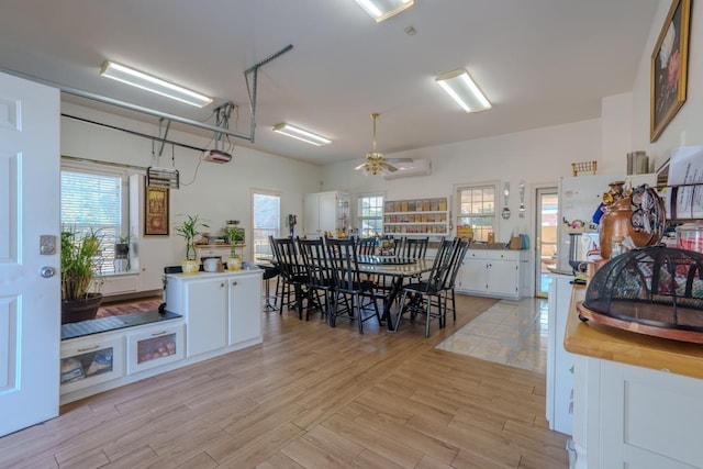 dining space with light hardwood / wood-style flooring and ceiling fan