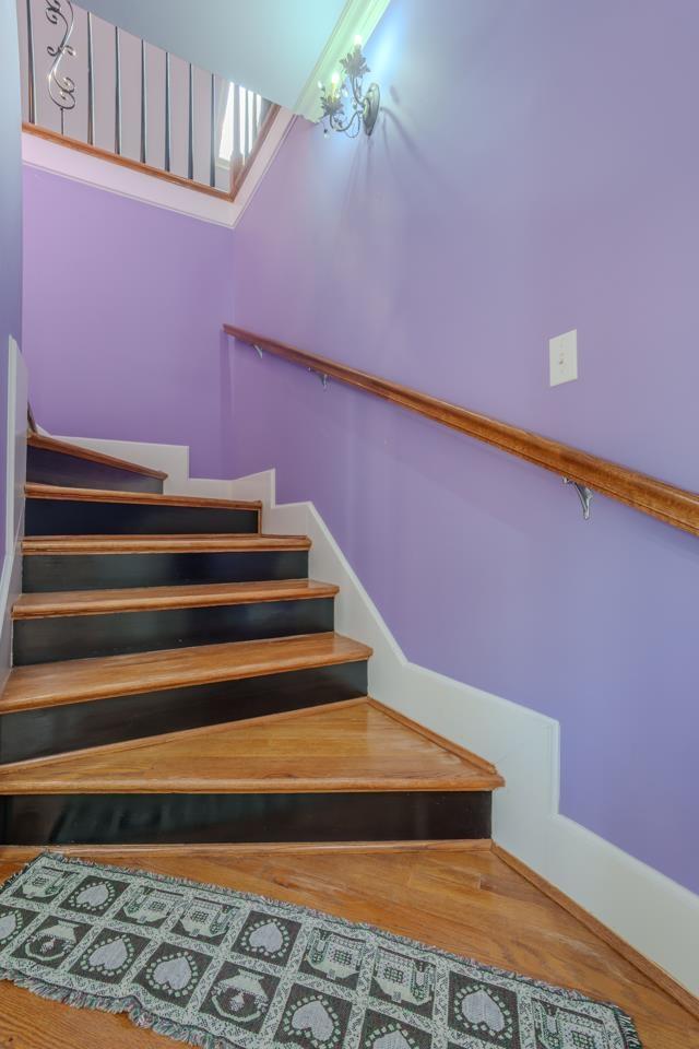 stairway with a towering ceiling and hardwood / wood-style flooring