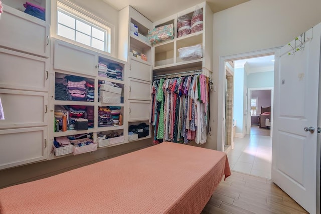 walk in closet with light hardwood / wood-style floors