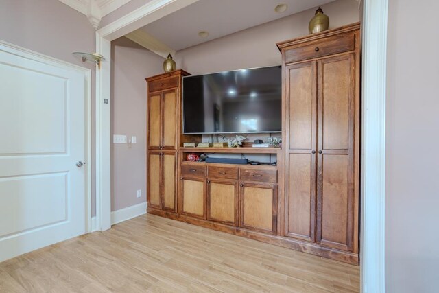 bar featuring light hardwood / wood-style flooring and crown molding