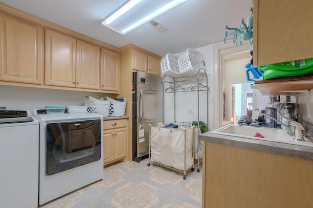 laundry area with washer and dryer, cabinets, and sink