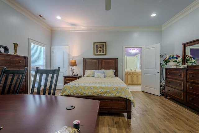 bedroom with light hardwood / wood-style floors, ornamental molding, and ensuite bath