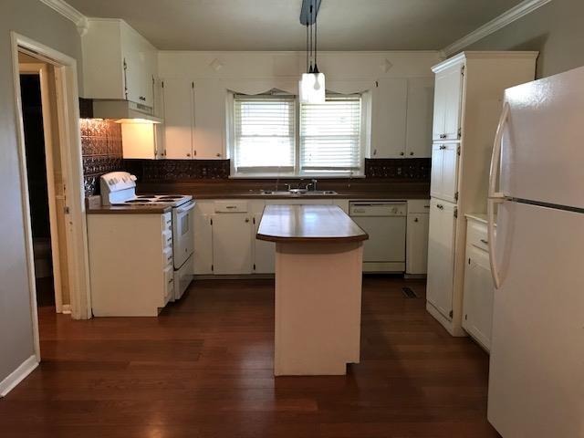 kitchen featuring a kitchen island, dark hardwood / wood-style flooring, decorative light fixtures, white appliances, and white cabinets