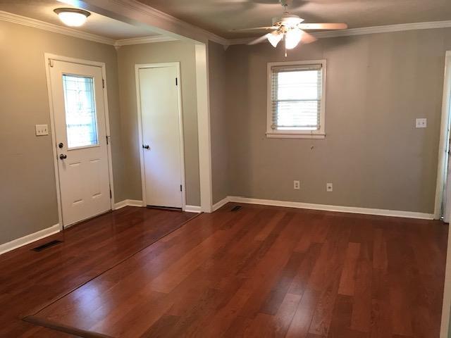 foyer featuring ceiling fan, ornamental molding, and dark wood-type flooring