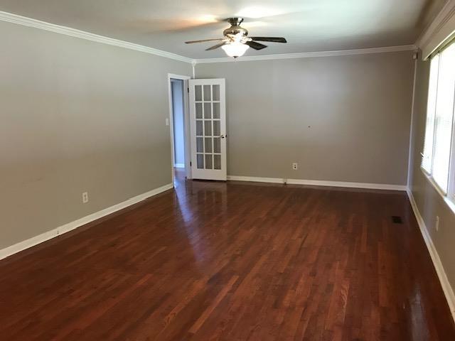 empty room with french doors, dark hardwood / wood-style flooring, ceiling fan, and crown molding