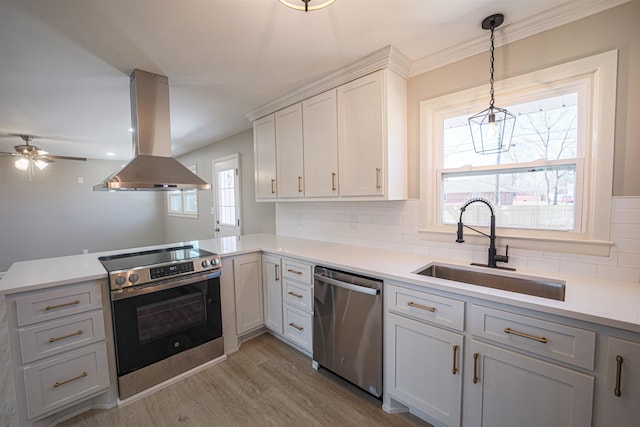 kitchen featuring appliances with stainless steel finishes, sink, white cabinets, island exhaust hood, and kitchen peninsula