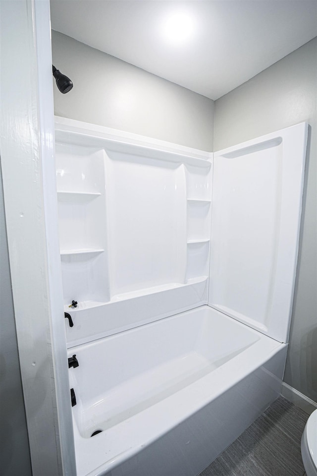 bathroom with tile patterned floors, toilet, and washtub / shower combination