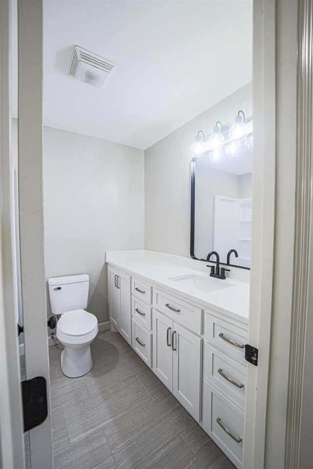 bathroom featuring vanity and toilet