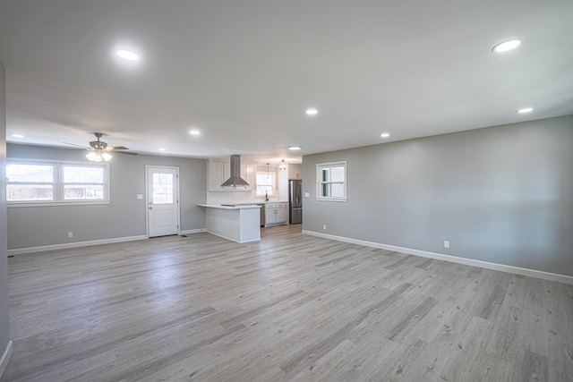 unfurnished living room featuring ceiling fan and light wood-type flooring