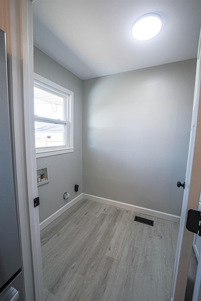 clothes washing area featuring washer hookup and light hardwood / wood-style floors