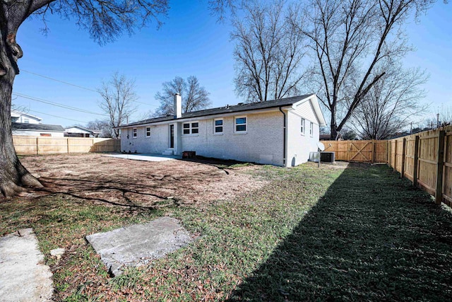 back of house with cooling unit, a patio, and a lawn